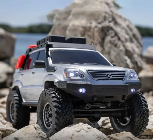 Toy SUV on rocky terrain with water and large rocks in the background